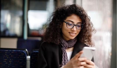 Woman wearing scarf on cell phone.