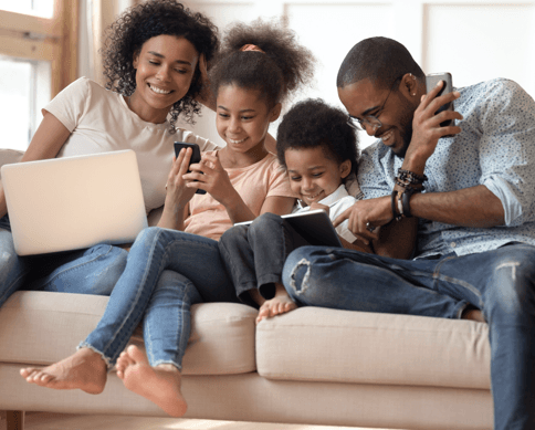 a family on a couch using different devices