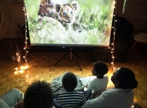 family watches movie on projector screen