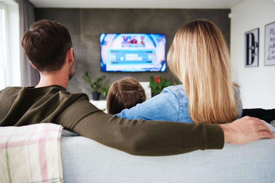a family watching TV from their couch
