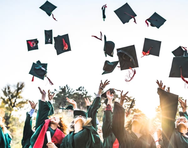 students throwing caps