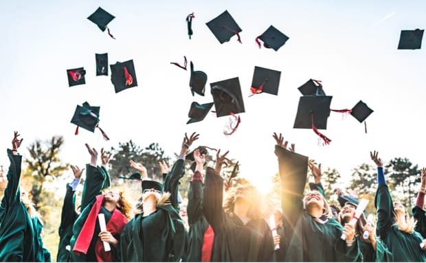 students throwing caps