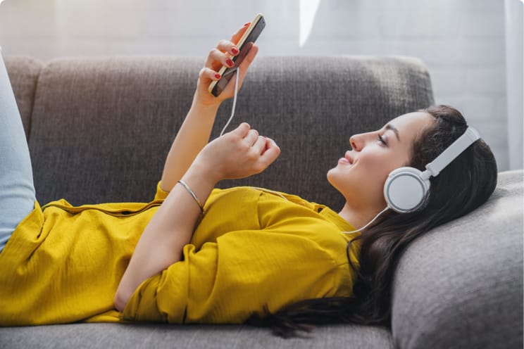 woman on a couch with headphones