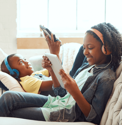Woman on the couch with her son using tablets