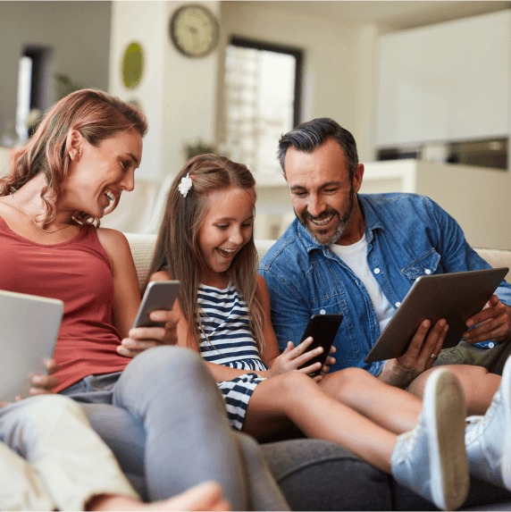 family on couch with devices