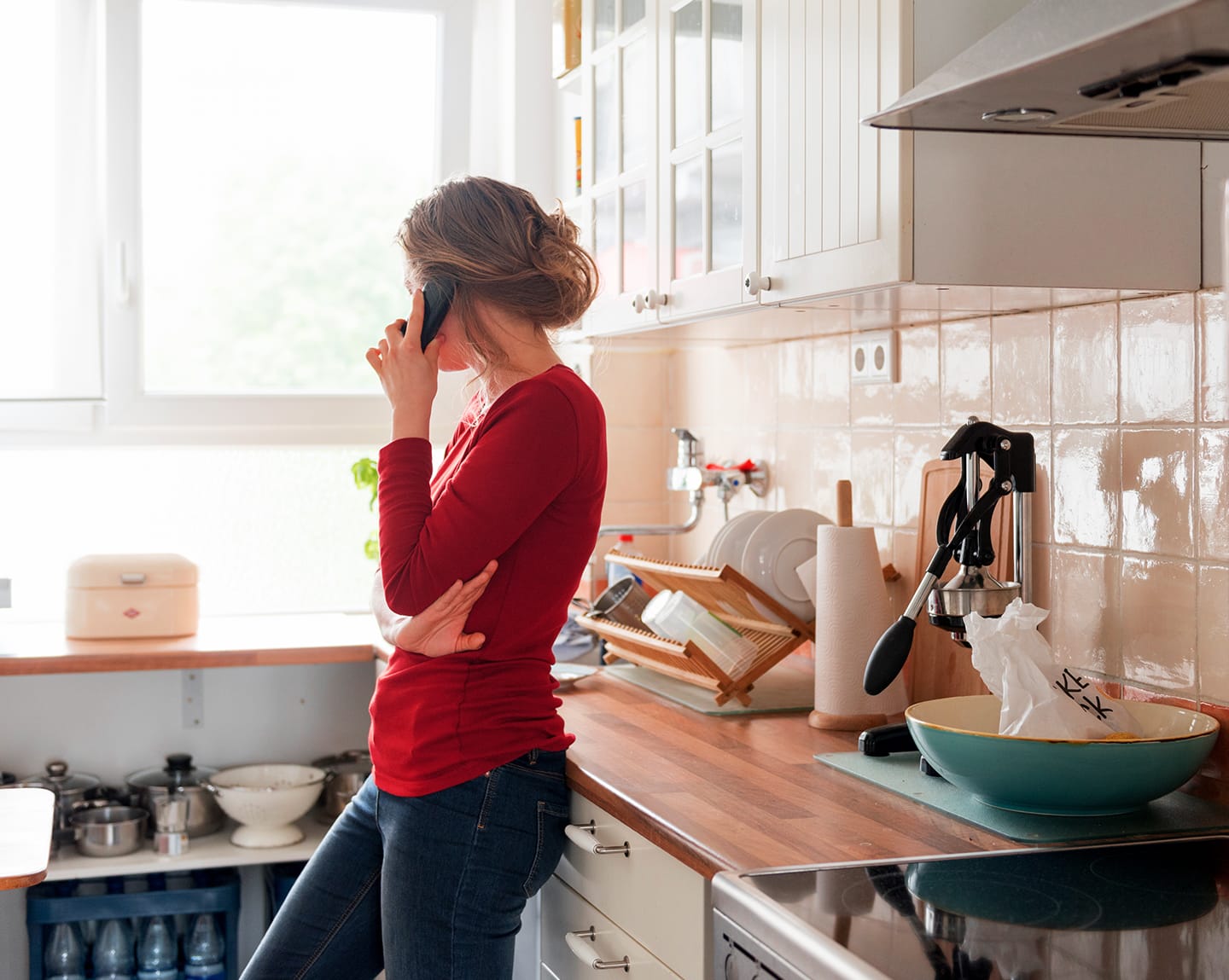 woman talking on the phone in her kitchen