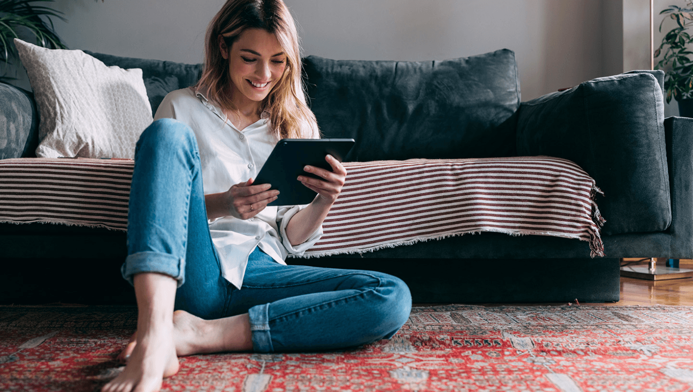 a woman sitting on the floor using a tablet