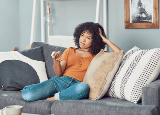 girl sitting on couch with remote