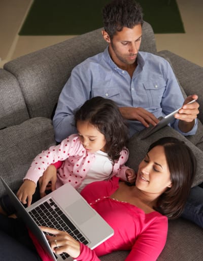 A family on the couch using devices