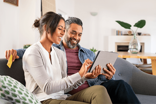man and woman smiling at tablet