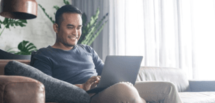 man on couch with laptop