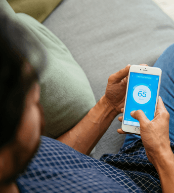 man using the vivint mobile app to control home's temperature