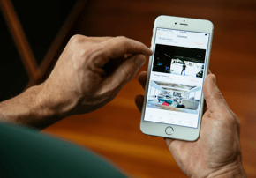 Father recording video clips using Vivint Playback™ of two sons playing basketball.