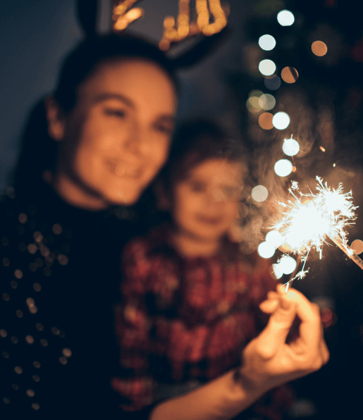 woman and child holding firework sparkler
