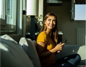 woman looks out window with smile on her face