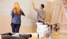 Couple painting interior home wall