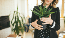 Woman holding a fake plant